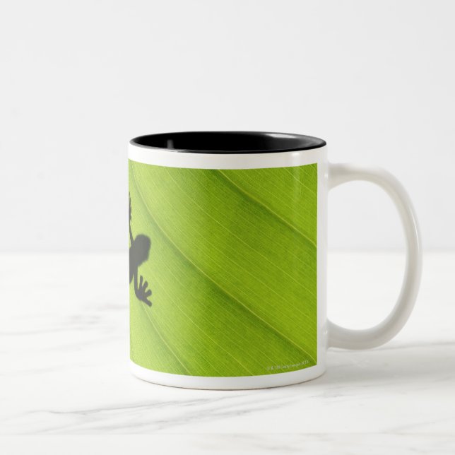Silhouette of frog through banana leaf Two-Tone coffee mug (Right)