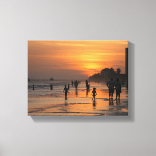 Silhouette people on beach at sunse canvas print