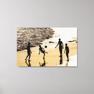 Silhouettes of Boys Playing Soccer on Golden Beach Canvas Print