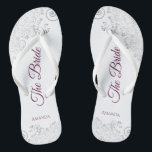 Silver Lace Cassis Purple The Bride White Wedding Flip Flops<br><div class="desc">Dance the night away with these beautiful wedding flip flops. Designed for the bride, they feature a simple yet elegant design with cassis purple, magenta, or berry colored script lettering on a white background and fancy silver gray lace curls and swirls. Beautiful way to stay fancy and appropriate while giving...</div>