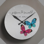 Silvery Gray Names Date Wedding Gift Personalized Round Clock<br><div class="desc">Beautiful connected by love silvery gray wall clock celebrating a couple and their love. Personalized with the couple's names written in cursive script and connected with a swirly heart. It's additionally personalized with a custom date. Decorated with a cute illustration of two butterflies, one purple one blue. Trendy, modern, and...</div>