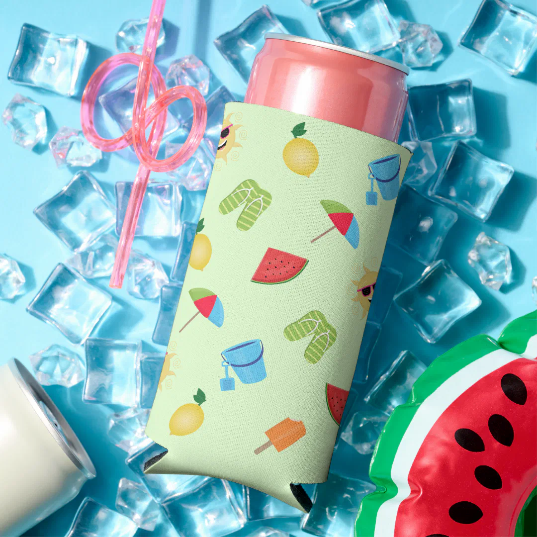 A light green slim can cooler covered in small illustrated summer motifs including watermelon, lemon, flip flops, a striped beach umbrella, a blue sand bucket, and an orange popsicle, photographed surrounded by loose ice cubes, a looped pink straw, a second plain can, and a watermelon-shaped inflatable on a vivid blue background.