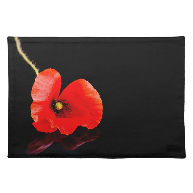 Single red poppy on black cloth placemat (Front)