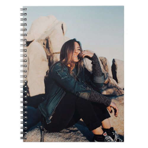 Sitting and smiling woman wearing black pants notebook