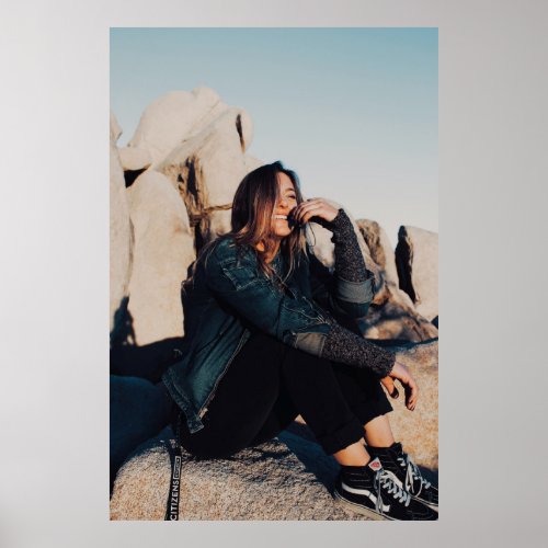 Sitting and smiling woman wearing black pants poster
