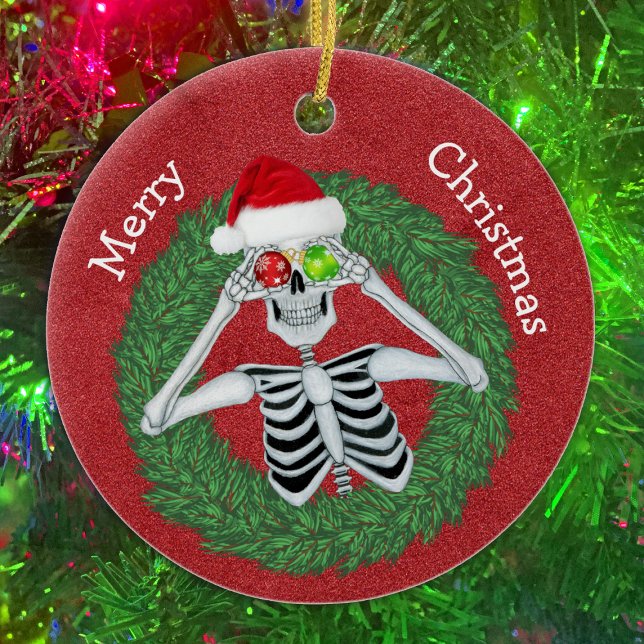 Skeleton in Pine Christmas Wreath Red Hat Funny Ceramic Ornament (Fun Skeleton With ornaments in pine Wreath on Red ceramic Christmas tree ornament.)