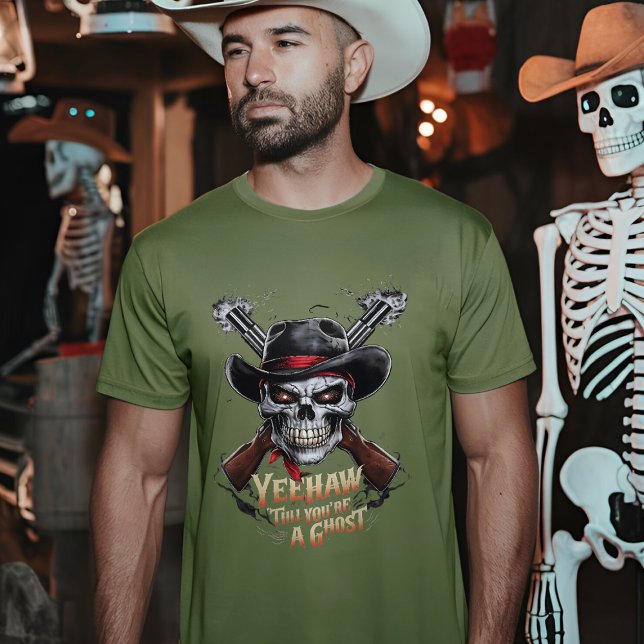 Skull Cowboy - Spooky Wild West T-Shirt (A man wearing a fatigue green t-shirt with a skull cowboy design stands in a dimly lit room)