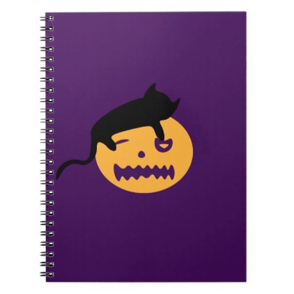 Sleeping cat on a pumpkin notebook