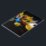 SlipperyJoe Hanukkah symbolic still life holiday e Notebook<br><div class="desc">SlipperyJoe Hanukkah symbolic still life holiday essence vibrant meaningful objects colorful slender pile menorah candles artistic red blue yellow and white sufganiyah doughnut classic jelly-filled commemorate miracle of the oil dreidels metallic gold glossy blue Hebrew great miracle happened there metallic pewter star of David medallion light resilience community themes spiritual...</div>