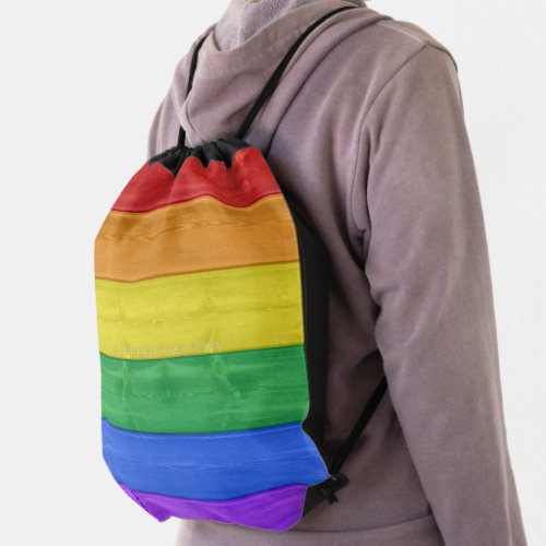 SlipperyJoes pride wooden flag rainbow colors cel Drawstring Bag