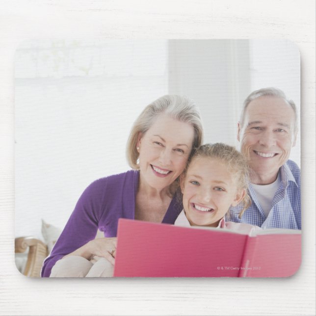 Smiling grandparents reading cookbook with mouse pad (Front)