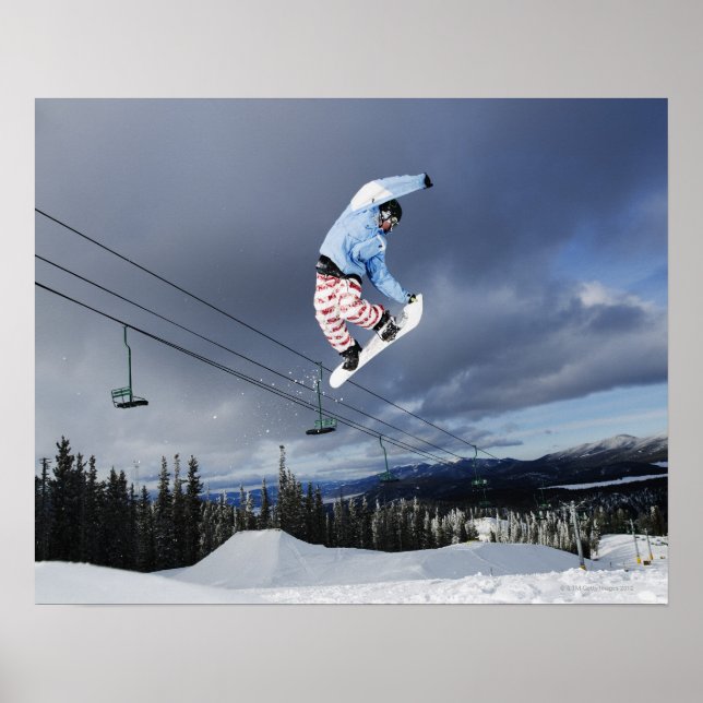 Snowboarder jumping in mid-air doing a backside poster (Front)