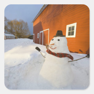 Snowman in front of red barn in Columbia Falls Square Sticker