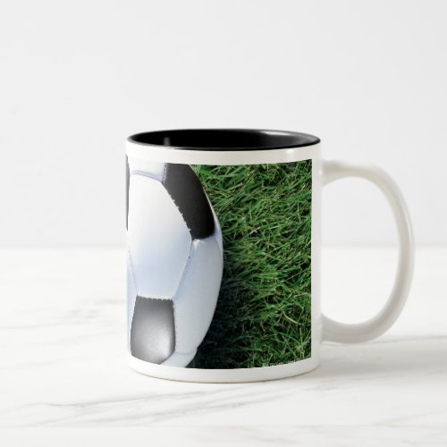 Soccer ball on green grass close_up Two_Tone coffee mug