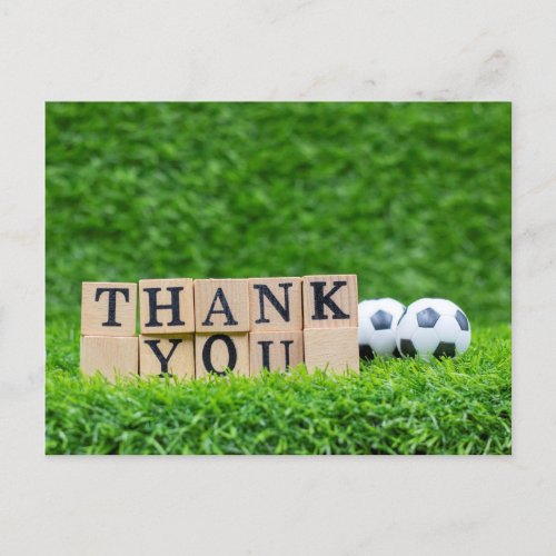 Soccer ball with Thank you word are on green grass Postcard