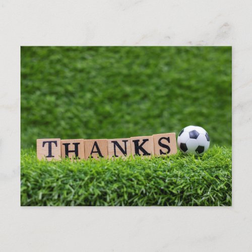 Soccer ball with Thanks word are on green grass Postcard