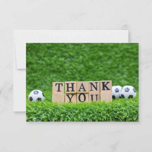 Soccer ball with word Thank you on green grass (Front)