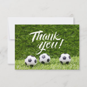 Soccer ball with word Thank you on green grass Card
