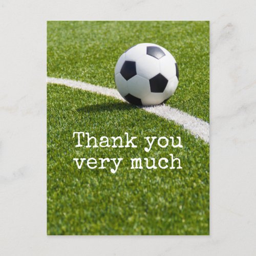 Soccer ball with word Thank you on green grass Postcard