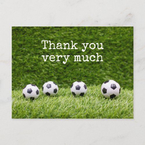 Soccer ball with word Thank you on green grass Postcard