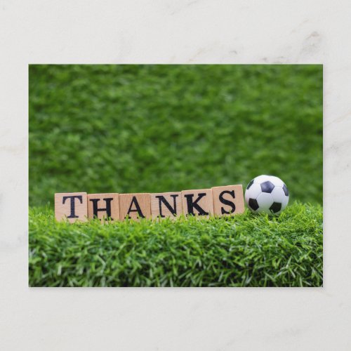 Soccer ball with word Thanks on green grass Postcard