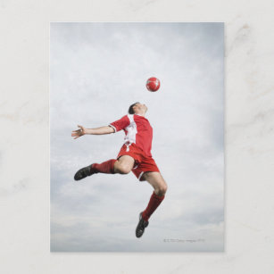 Soccer player and soccer ball in mid-air postcard