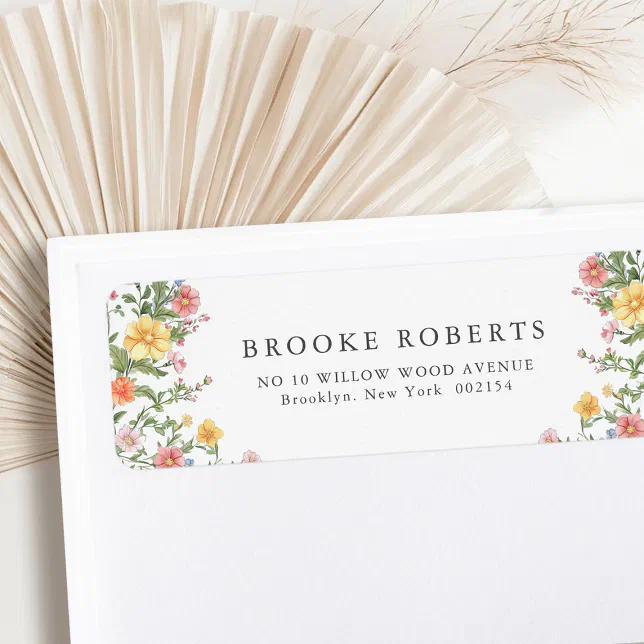 A wedding return address label. A floral border surrounds the text on either side.