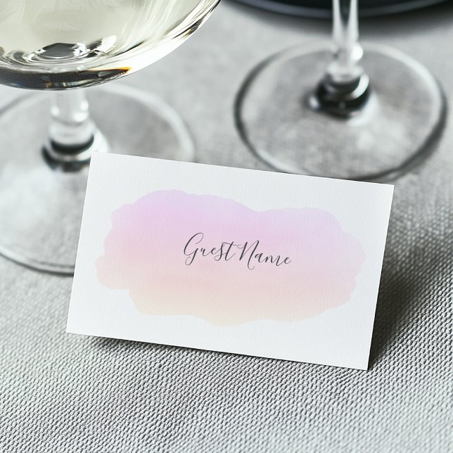 Soft pink watercolor guest name place card (Soft watercolor pink paint wash on a white guest name place card at a wedding dining table)