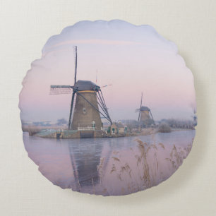 Soft sunrise light in winter over windmills round pillow