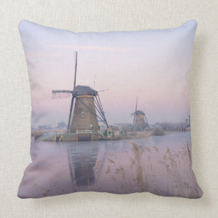 Soft sunrise light in winter over windmills throw pillow