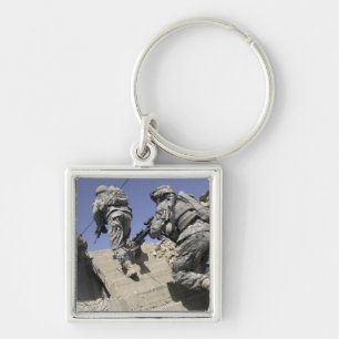 Soldiers running up staircase of a building keychain