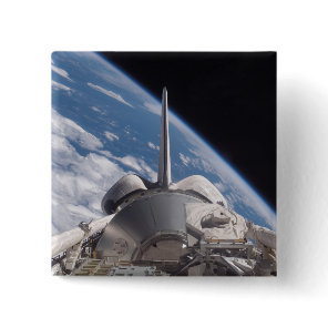 Space Shuttle Discovery backdropped by Earth Button