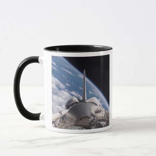 Space Shuttle Discovery backdropped by Earth Mug (Left)