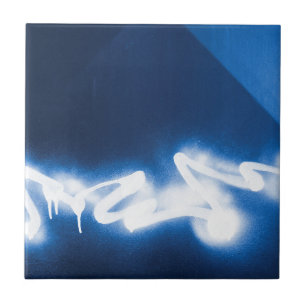 Sprayed graffiti on blue metal ceramic tile