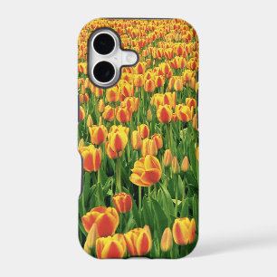 Spring tulips bloom in front of old barn. iPhone 17 case