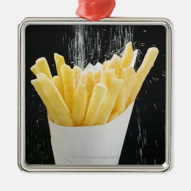 Sprinkling salt on chips in paper cone metal ornament (Front)