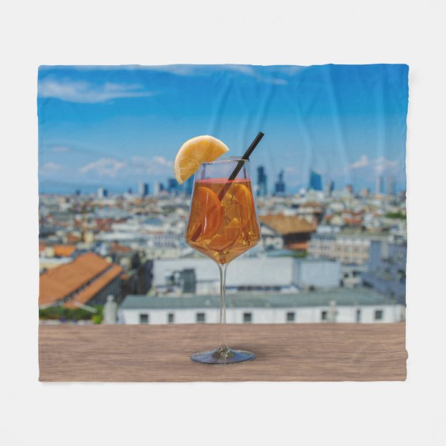Spritz cocktail on a table with view of Milan Fleece Blanket (Front (Horizontal))