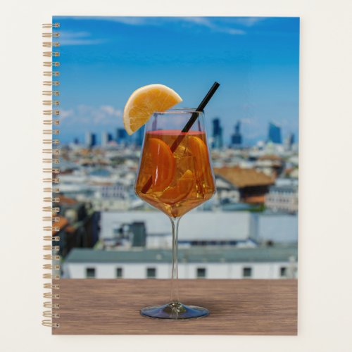 Spritz cocktail on a table with view of Milan Planner