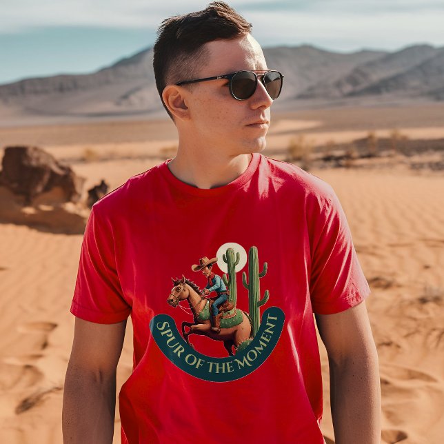 Spur of the Moment Cowboy Graphic T-Shirt (A man wearing a cardinal t-shirt with a cowboy and cactus design stands in a desert landscape)