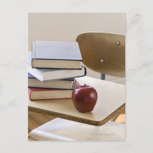 Stack of books apple and school desk postcard