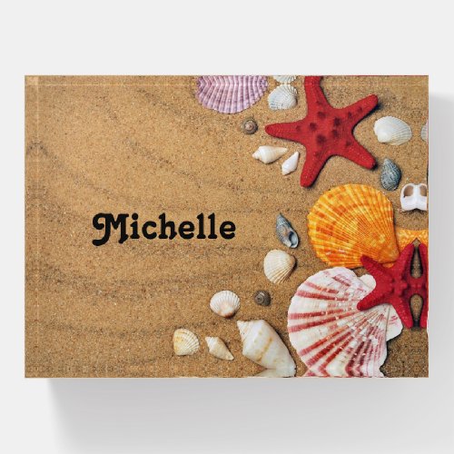 Starfish and seashells on brown beach sand paperweight