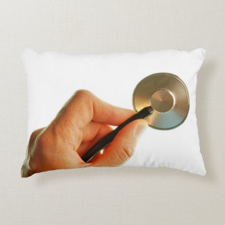 Stethoscope in a hand for a hospital atmosphere. accent pillow
