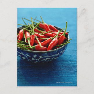Still life of chilies in bowl on blue mat postcard