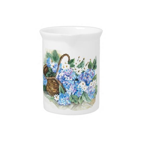 Straw basket with blue hydrangeas and white little drink pitcher