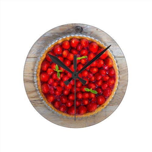 Strawberry cake with mint leaves on a rustic wood round wall clock