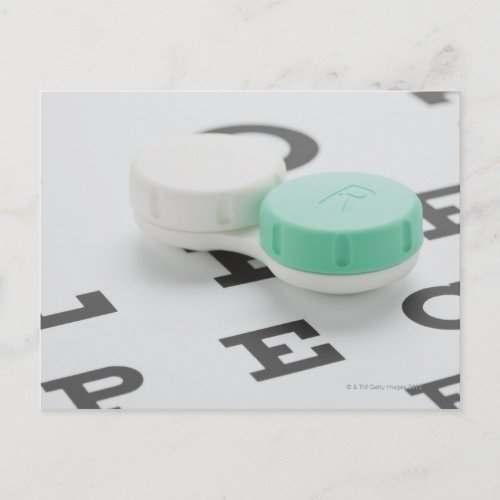 Studio shot of contact lens case on eye chart postcard