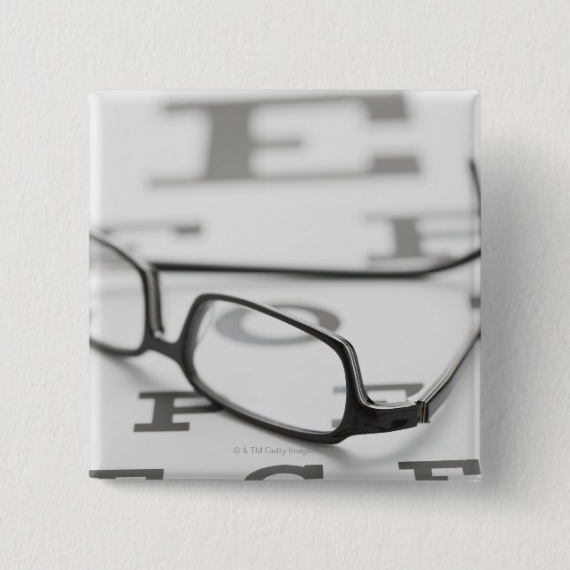 Studio shot of eyeglasses on eye chart pinback button (Front)