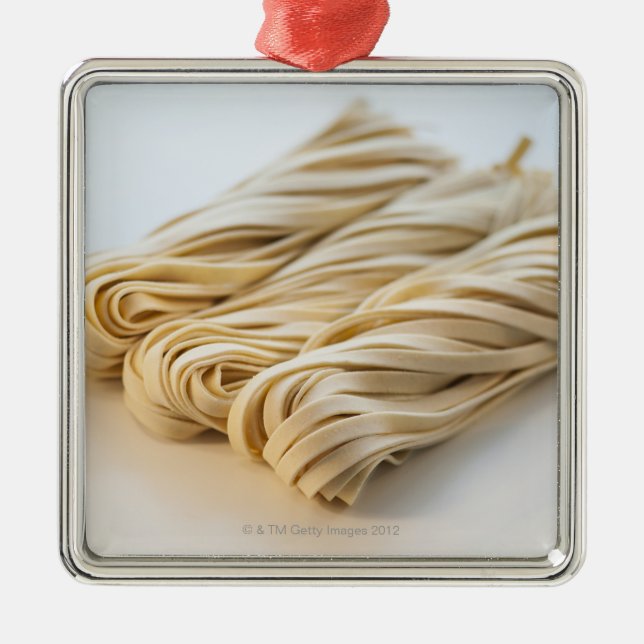 Studio shot of fresh linguini pasta metal ornament (Front)