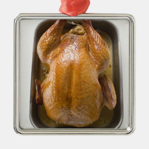 Stuffed roast turkey in roasting tray, close up metal ornament