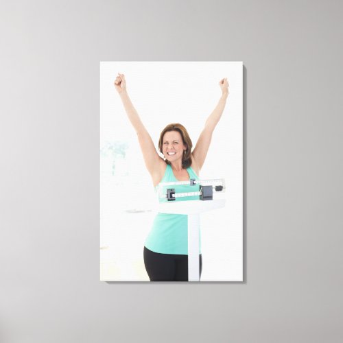 Successful weight loss Happy woman weighing Canvas Print